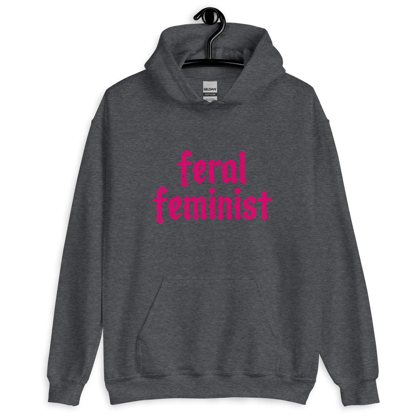A charcoal grey hoodie with hot pink graphic that says ' Feral Feminist’ hanging on a hanger rewilding by Rebel Girl Rampage