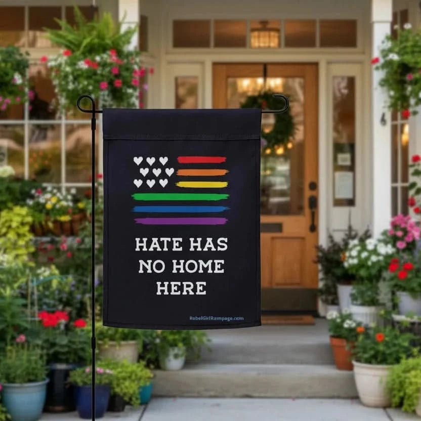woke garden flag with rainbow design and hearts with 'Hate has no home here' text in front of a house entrance.
