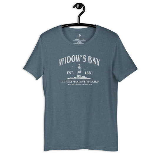 Widow’s Bay Heather Slate Unisex T-Shirt with a graphic of a lighthouse saying, “The Next Martha’s Vineyard. And definitely not cursed” Featuring a lighthouse at Rebel Girl Rampage