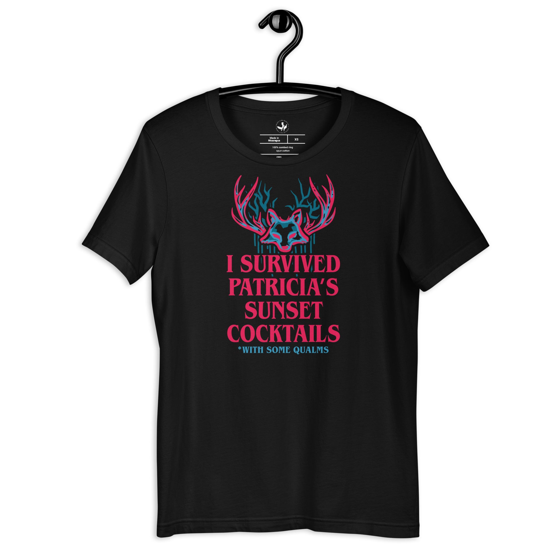 Black unisex t-shirt on a hanger with a psychedelic graphic that says, “I survived Patricia’s Sunset Cocktails” at Rebel Girl Rampage 