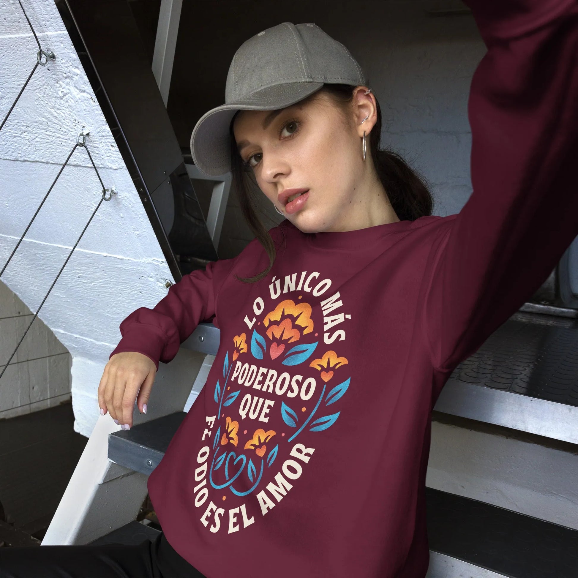 Burgundy unisex crewneck sweatshirt with a flower graphic and words that say, "Lo unicorn has poderoso que el odio es el amor." Love is more powerful than hate, bad bunny quote, super bowl halftime show 2026, Rebel Girl Rampage