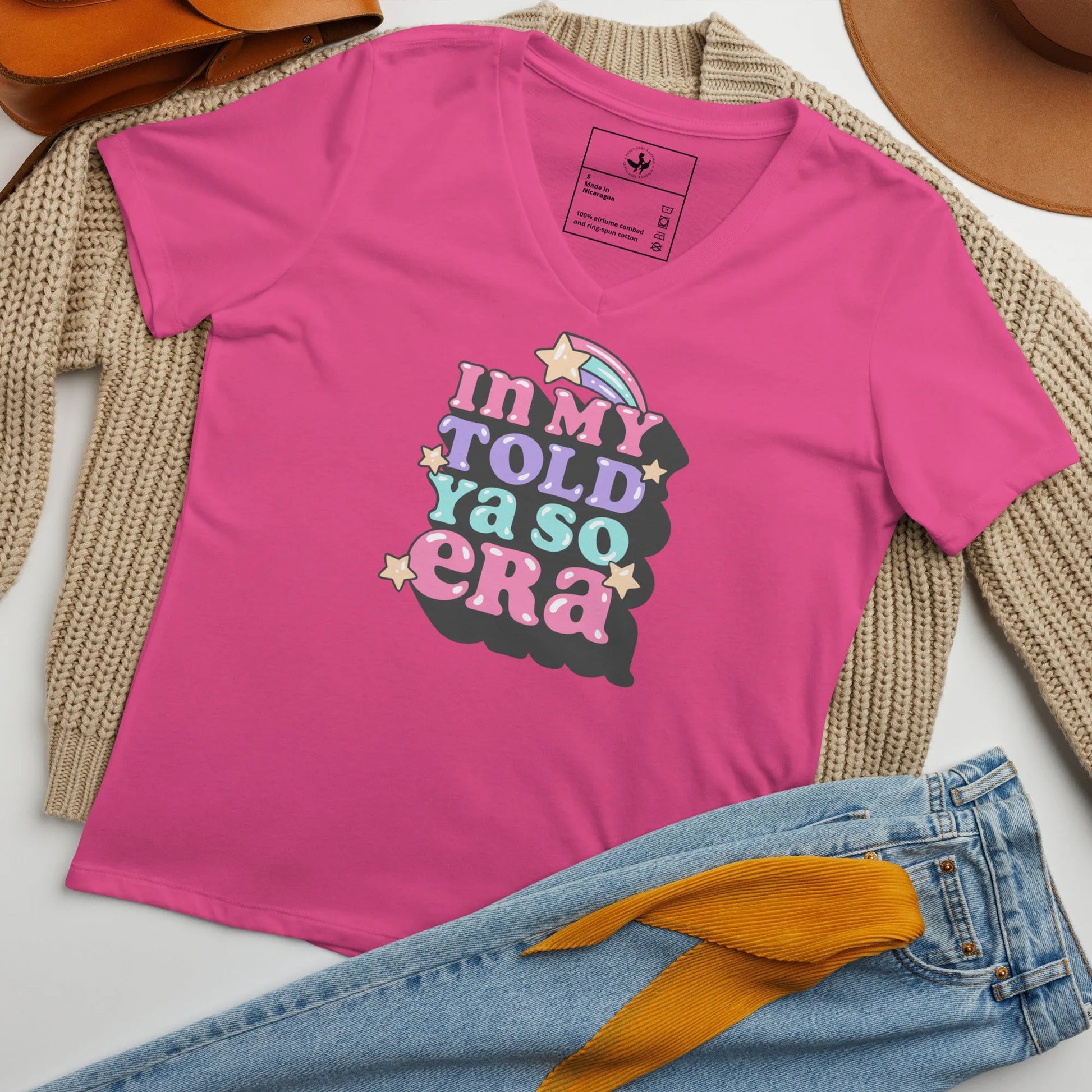 Pink v-neck t shirt with "In my told ya so era" pink, purple, and light blue graphic lettering with stars, speak your mind and tell them, "I told ya so" with a shirt as sassy as you, Rebel Girl Rampage.
