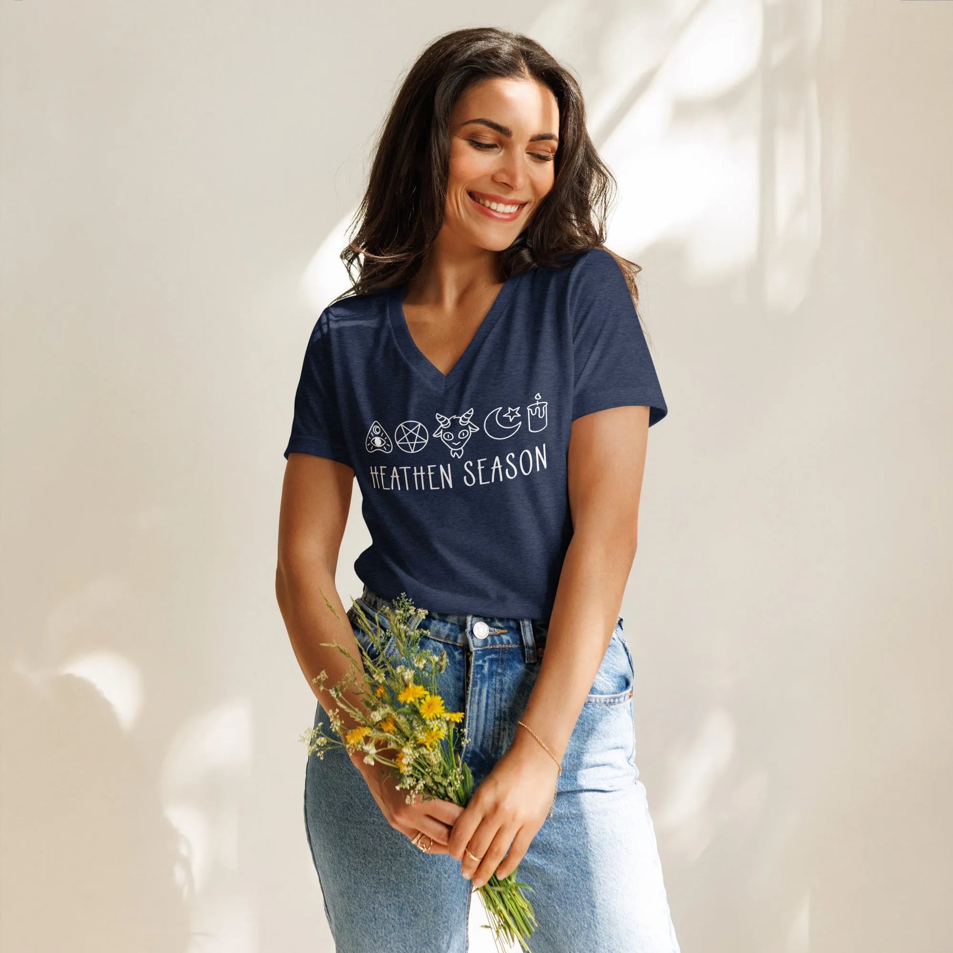 Heathen Season navy triblend women’s v neck t-shirt, adorable graphic of a pentagram, goat head , moon and stars, candle and ouija board symbols above the words “Heathen Season” ,  Anne Lesniak, Rebel Girl Ramage 