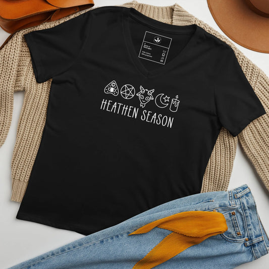 Heathen Season black women’s v neck t-shirt, adorable graphic of a pentagram, goat head , moon and stars, candle and ouija board symbols above the words “Heathen Season” ,  Anne Lesniak, Rebel Girl Ramage 