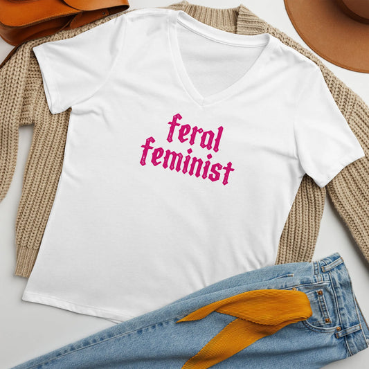 Feral Feminist pink letter graphic women’s white v neck t shirt styled with jeans and a sweater at Rebel Girl Rampage